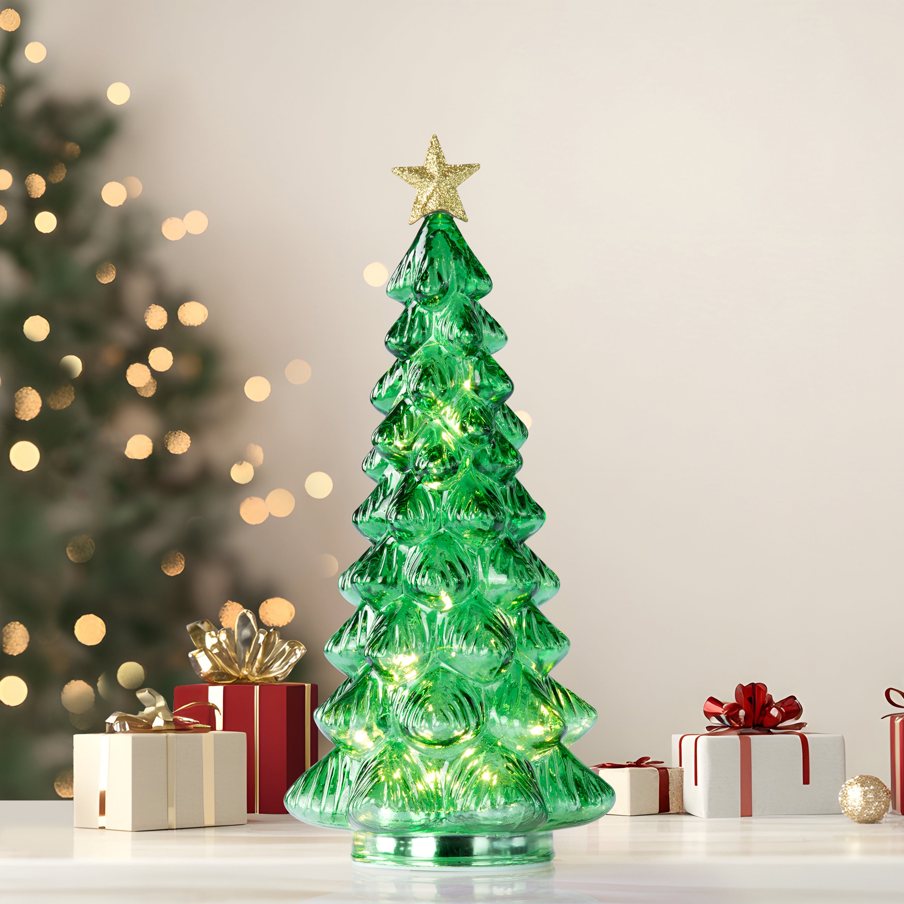 A green Christmas tree-shaped lighted candle or lamp with a gold star on top, shown on a festive background with presents