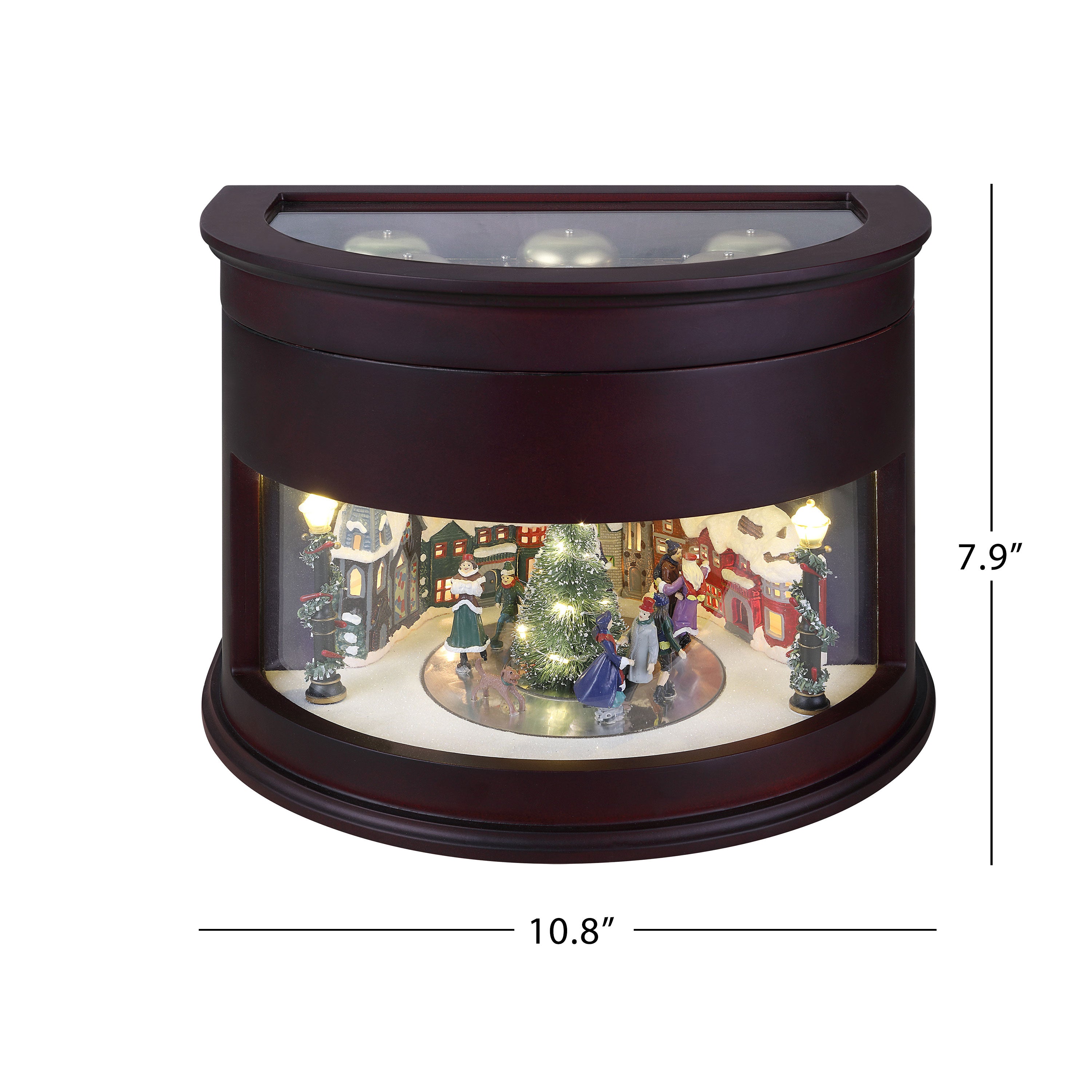 A round wooden Christmas music box display case with a glass top and illuminated winter village scene inside, shown with dimension lines indicating 10.8 inches wide by 7.