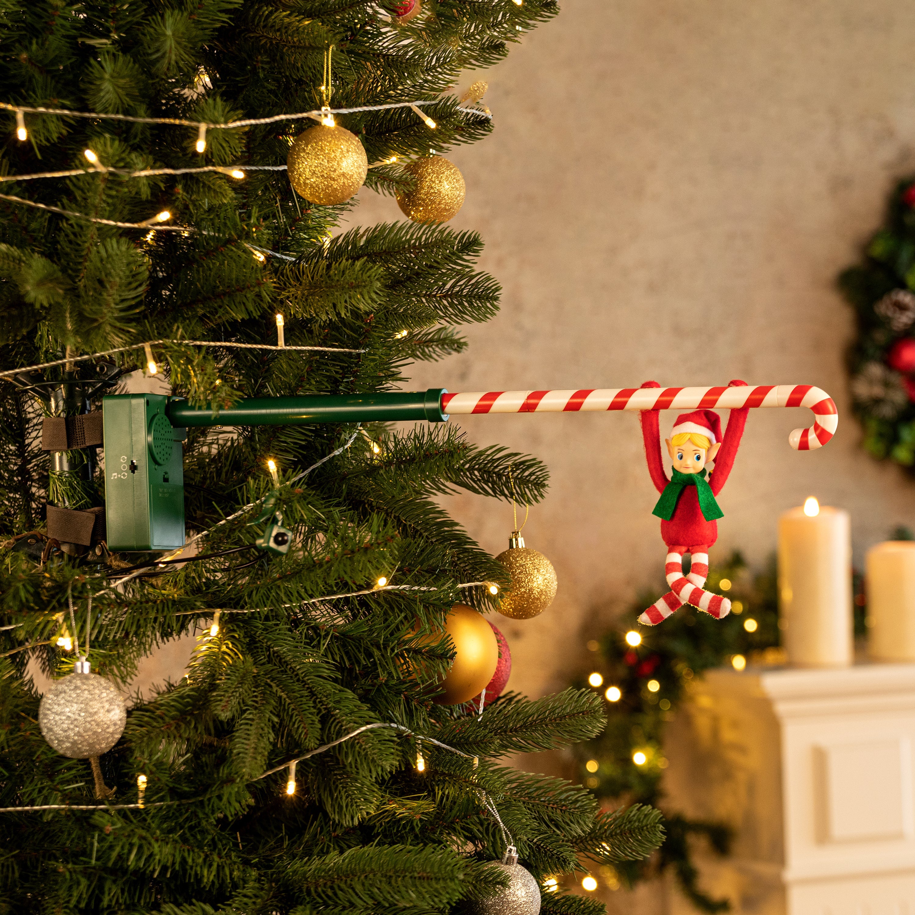 Candy Cane Elf Acrobat by Mr. Christmas secured to Christmas tree using included arm and strap in a festive holiday background