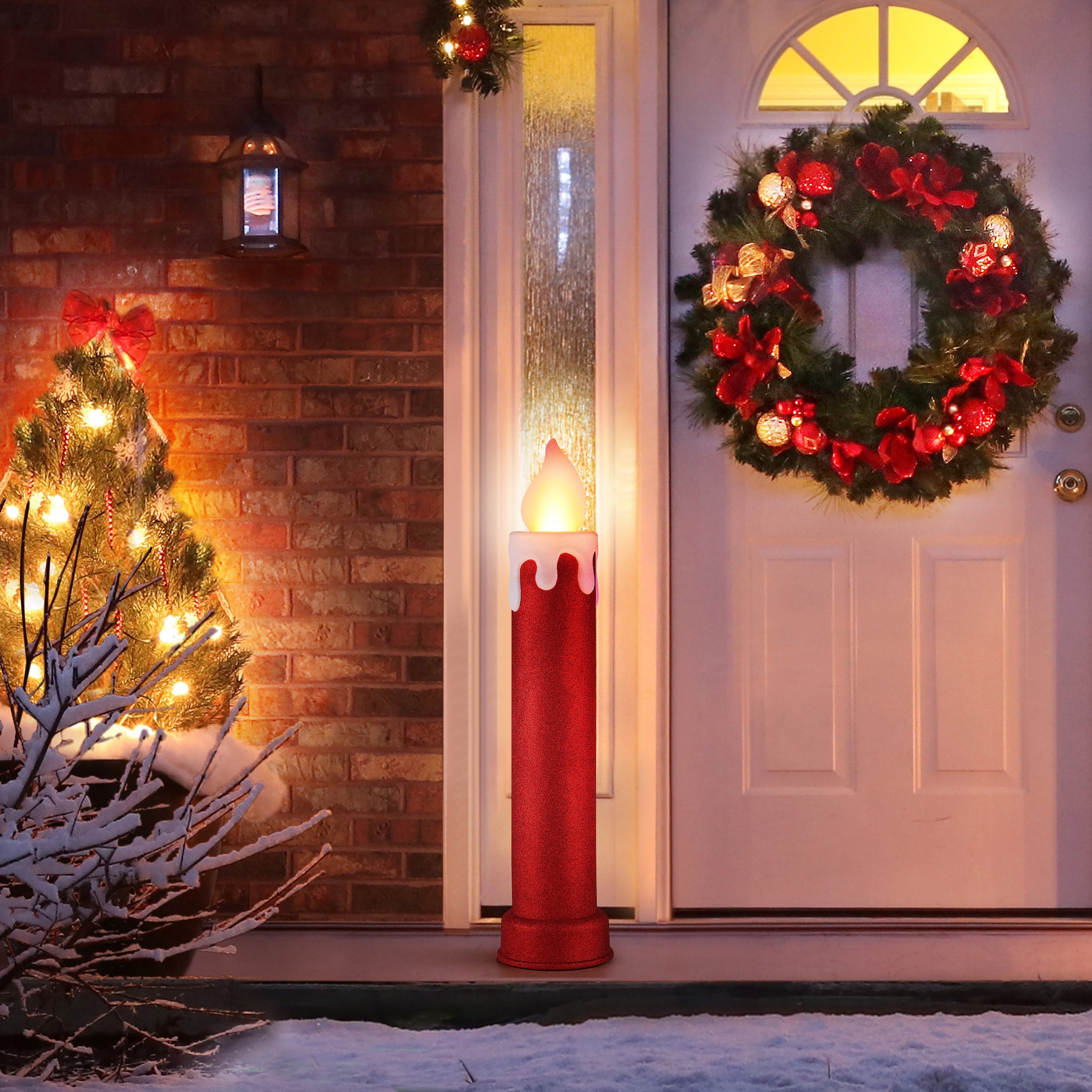 Red glitter blow mold candle by Mr. Christmas glowing on a front step beneath a holiday wreath