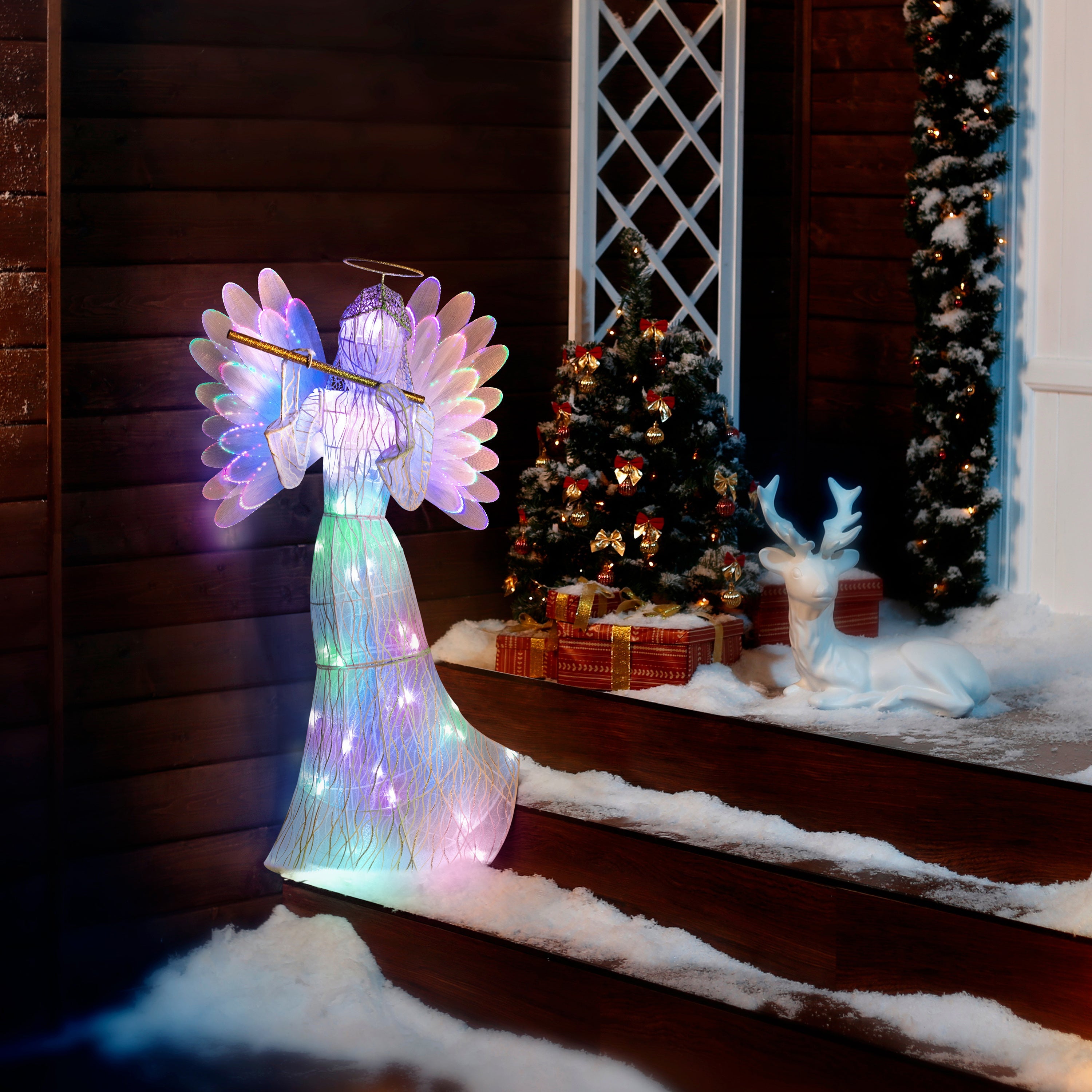 3' animated fiber-optic angel by Mr. Christmas displayed on snowy front steps, glowing in festive outdoor setting