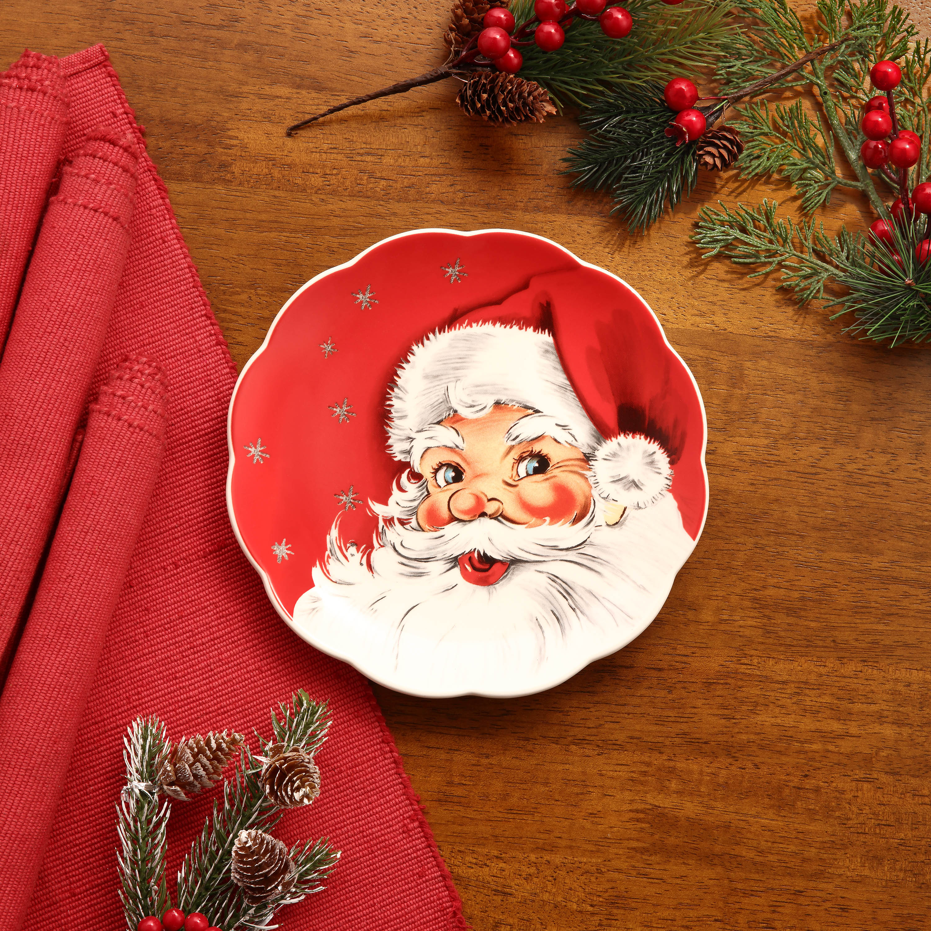 Red Santa nostalgic plate by Mr. Christmas shown on a festive table with red tablecloth and evergreen decor