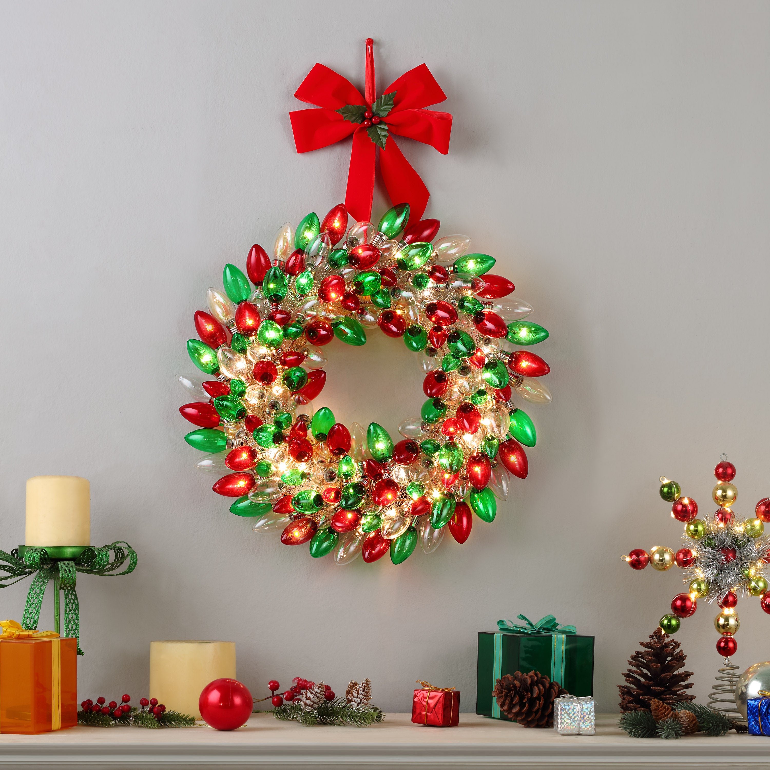 Mr. Christmas Retro C9 Bulb Wreath glowing on the wall above a fireplace mantel