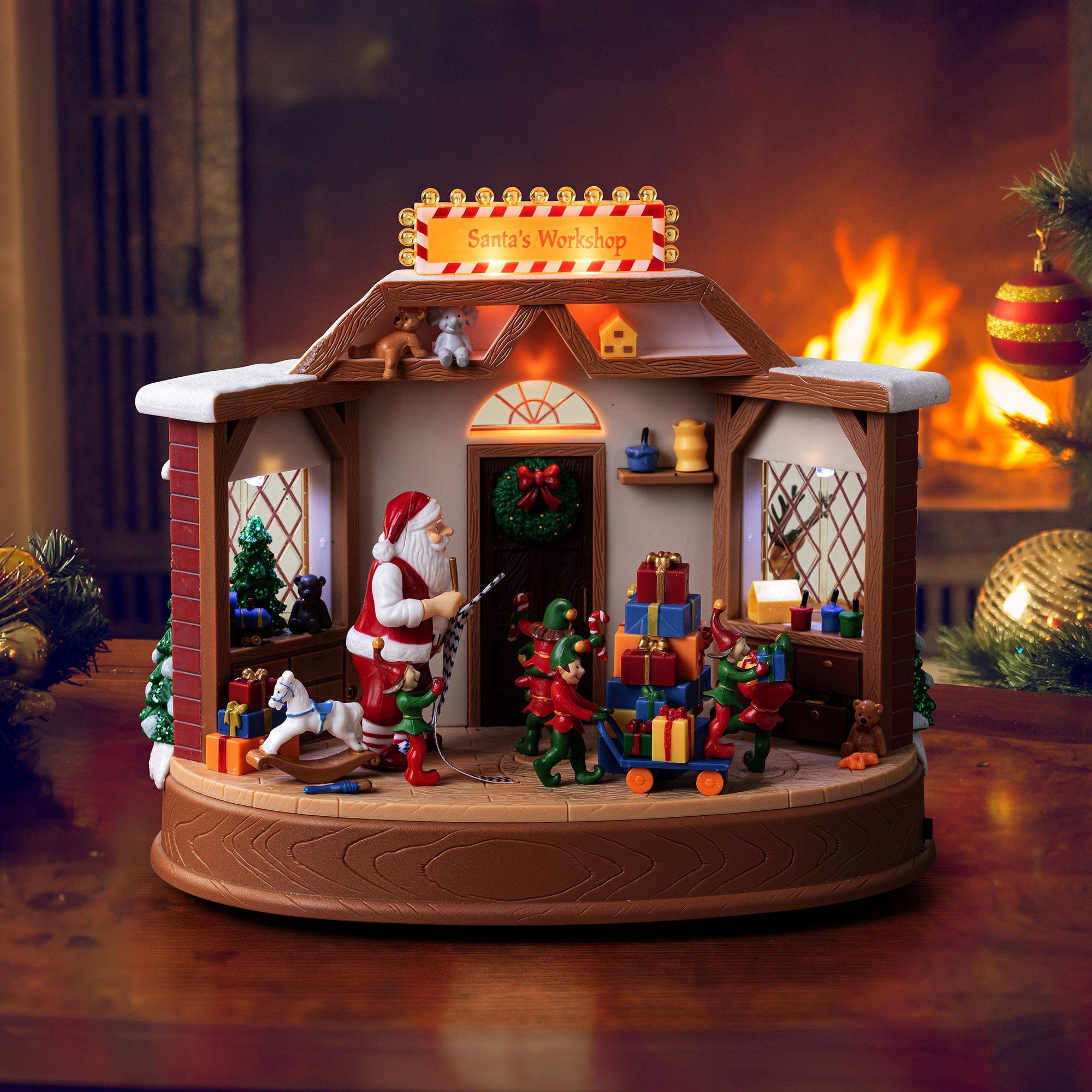 Mr. Christmas Santa’s Workshop scene displayed in front of a fireplace with festive holiday surroundings