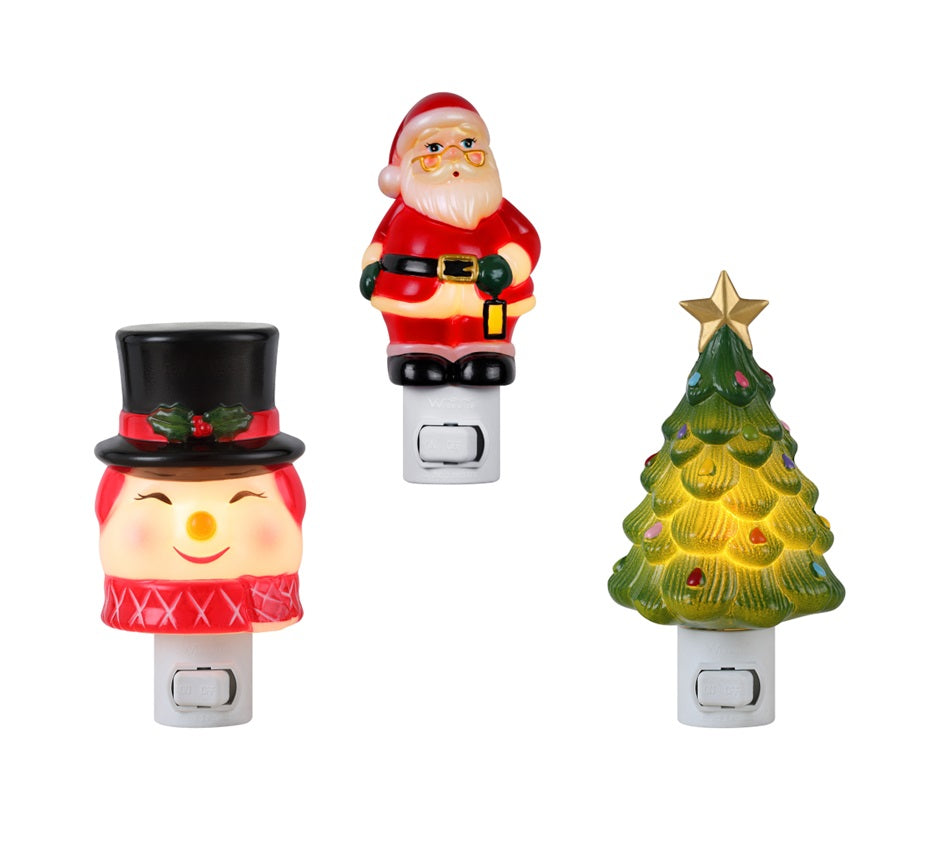 Three Christmas-themed night lights on a white background