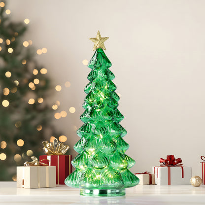 A green Christmas tree-shaped lighted candle or lamp with a gold star on top, shown on a festive background with presents
