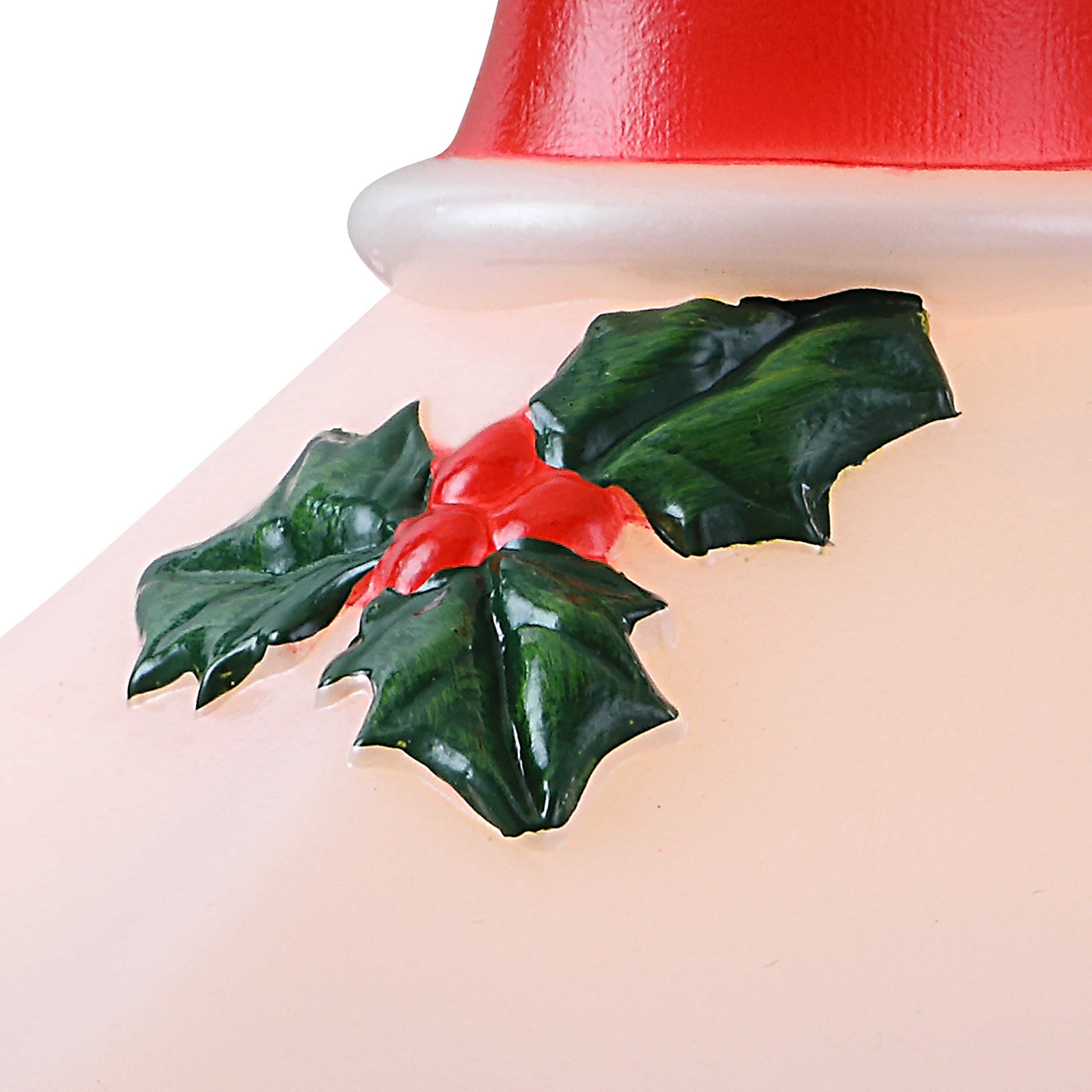 Close-up of a Christmas lantern glossy green holly leaves, red berries, and part of a red-and-white hat on a pale pink body against a white background.