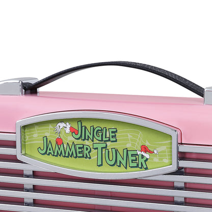 Close-up of a pink grinch radio area with a black handle and a green sign reading 'Jingle Jammer Tuner' on a white background.