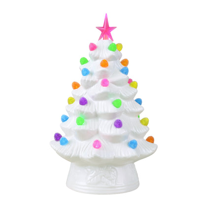 A white ceramic Christmas tree ornament with colorful glittery pom-pom decorations and a pink star topper, set against a plain white background.