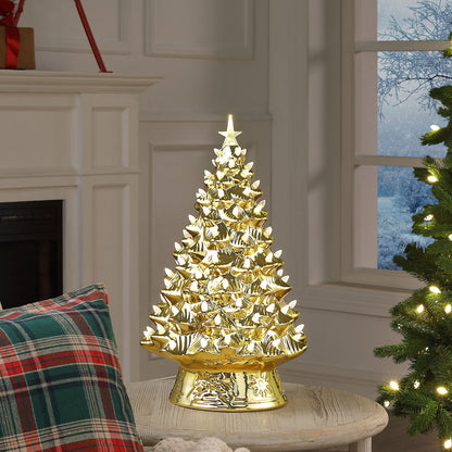 A gold Christmas tree lamp with glowing white lights and a star topper, displayed on a table in a cozy holiday room setting.