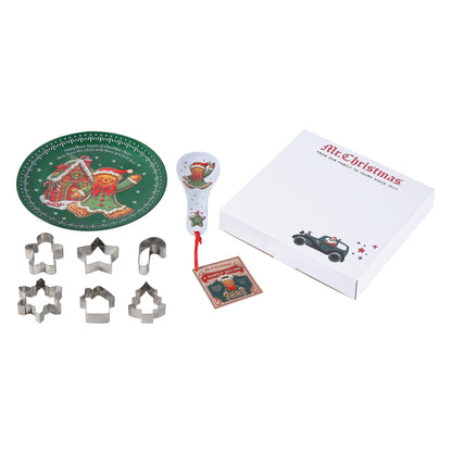 A Christmas-themed cookie cutter set displayed on a white background, including six metal cookie cutters, a green printed cookie tray, a white spoon with a Santa illustration and red string, a small card, and a white gift box labeled 'Mr. Christmas'.