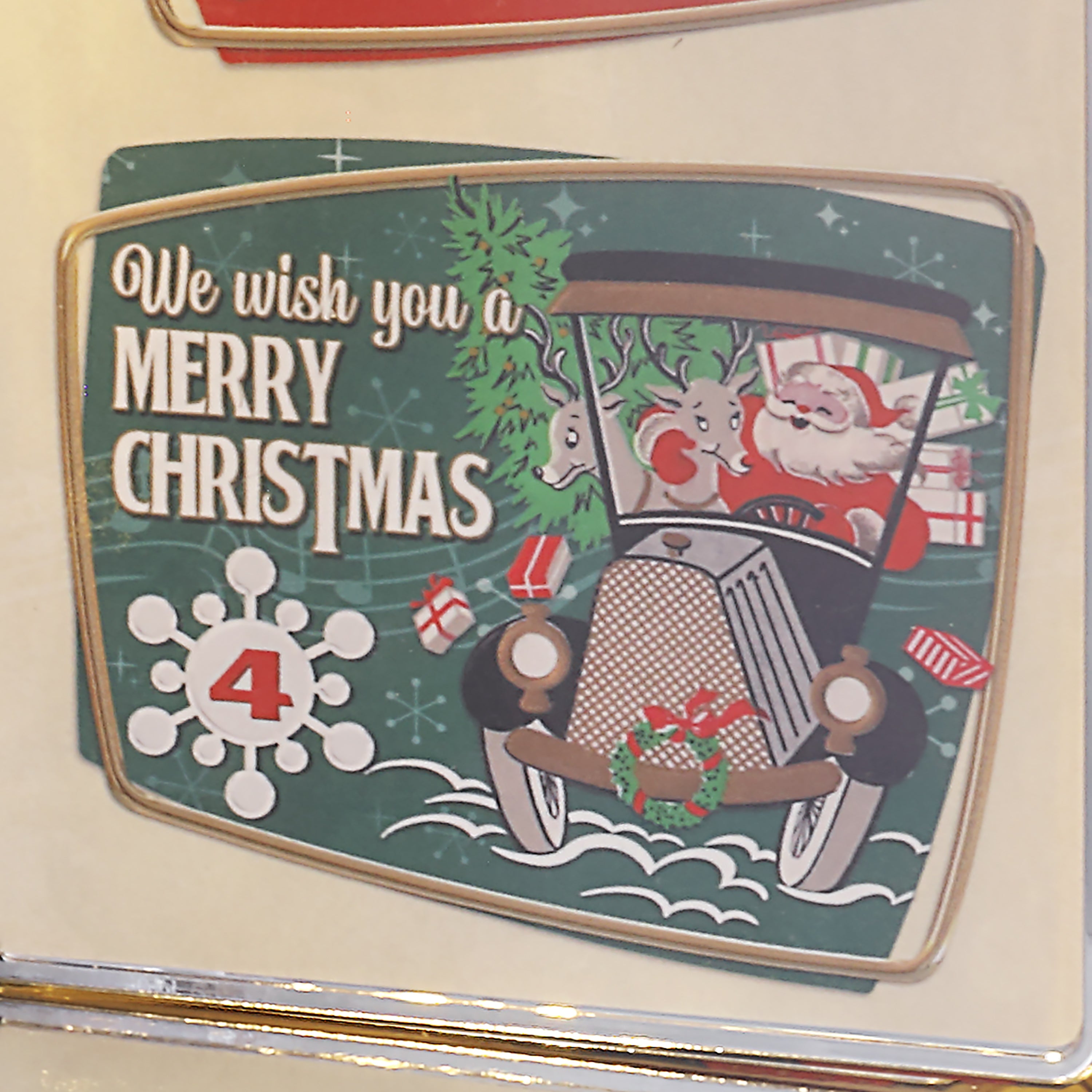 A vintage-style Christmas image with the text 'We wish you a Merry Christmas' and an illustration of Santa Claus driving a car with a tree on top, shown against a cream background.