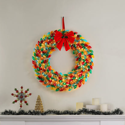 Mr. Christmas 30 in. Retro C9 Bulb Wreath Multi-Color hung on wall with festive decor on a mantel place