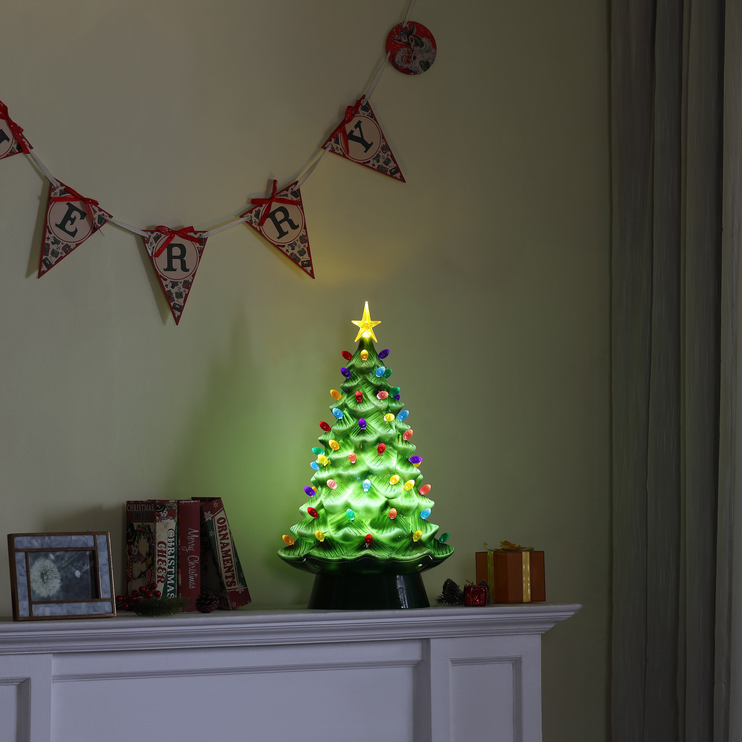 Mr. Christmas green nostalgic tree displayed on mantel with Christmas banner and holiday décor