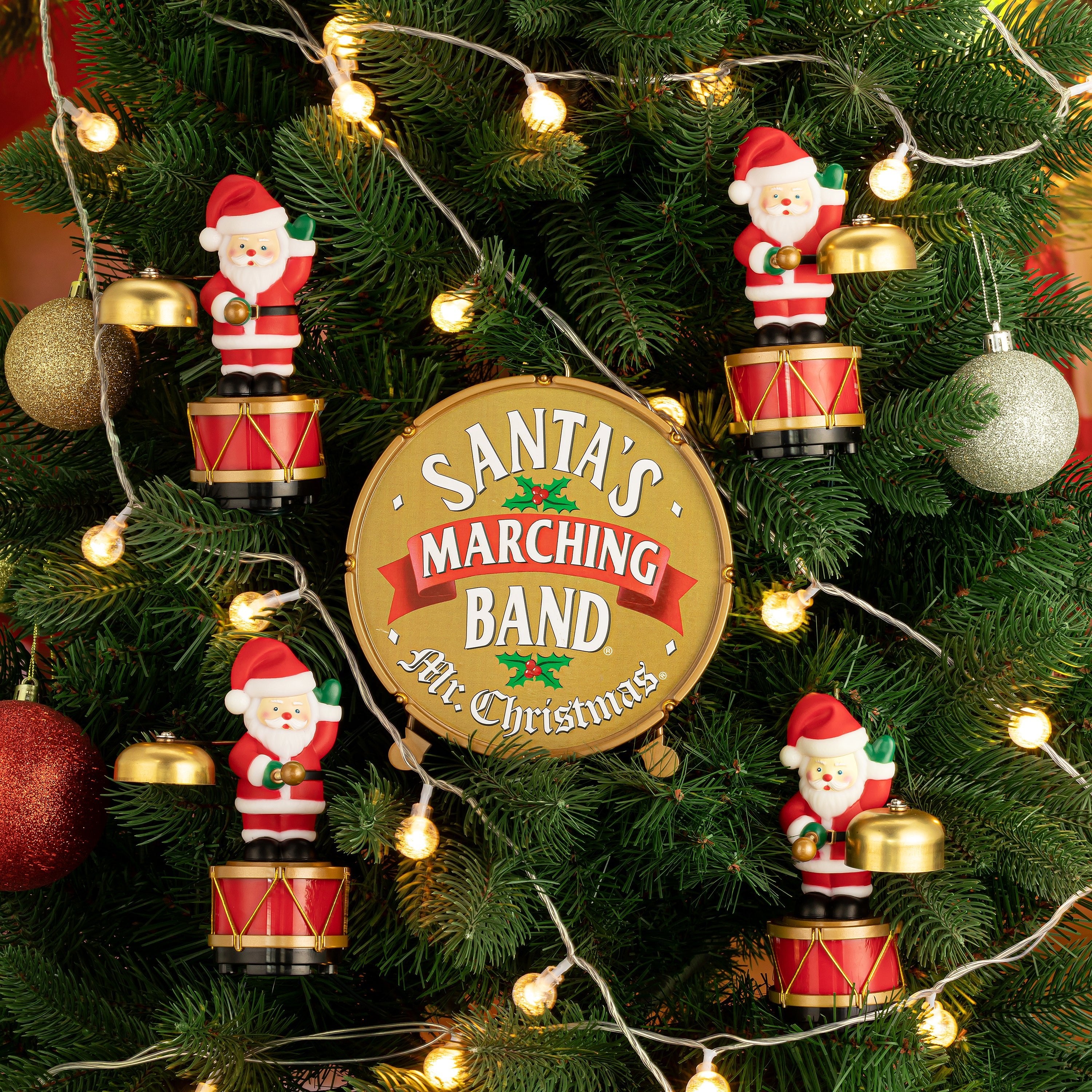 Close-up of Mr. Christmas Animated Santa's Marching Band hung as ornaments on a Christmas tree
