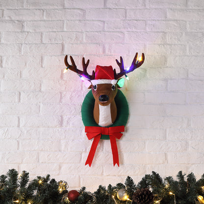 Mr. Christmas Animated Singing Reindeer hanging on a wall in festive holiday room
