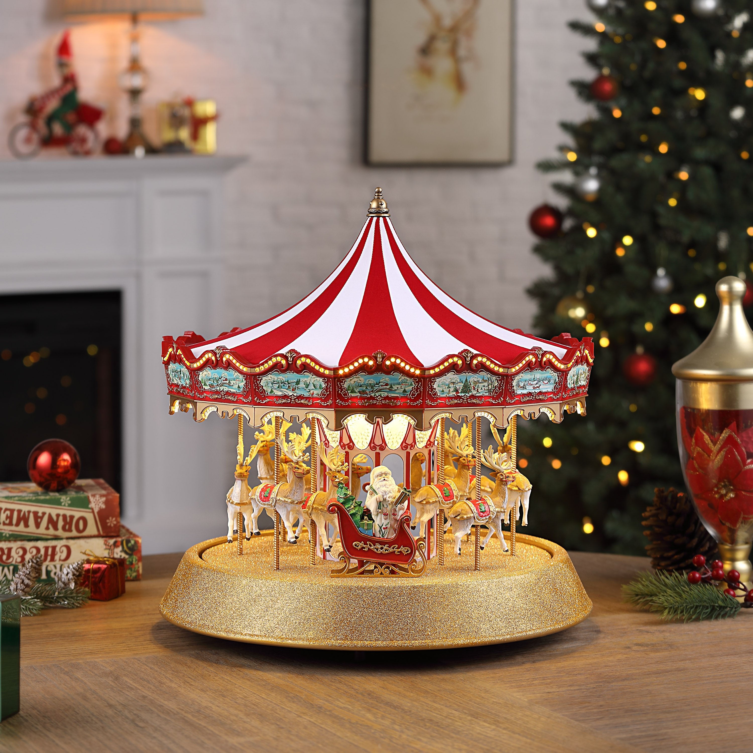 Mr. Christmas 17 in. Animated Sparkle Carousel shown on a tabletop next to a Christmas tree, with Santa riding in the sleigh.