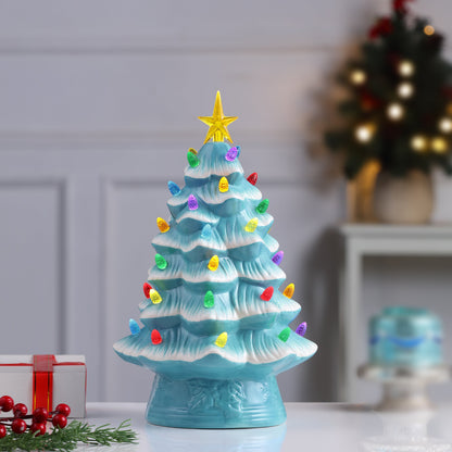Light blue Mr. Christmas nostalgic tree glowing on a tabletop with festive decor