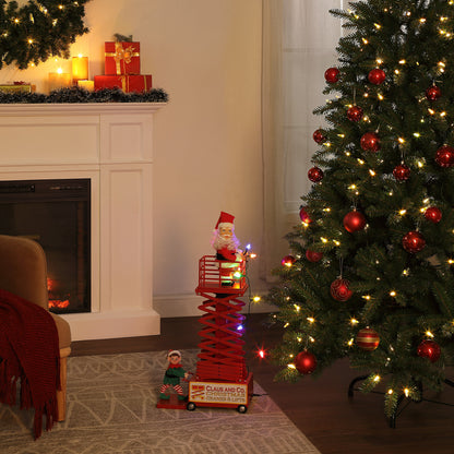 Mr. Christmas 50" Animated & Musical Santa's Lift - White Santa lifestyle showing the lift collapsed next to a decorated Christmas tree and fireplace in a festive background