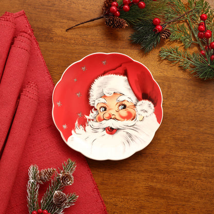 Red Santa nostalgic plate by Mr. Christmas shown on a festive table with red tablecloth and evergreen decor