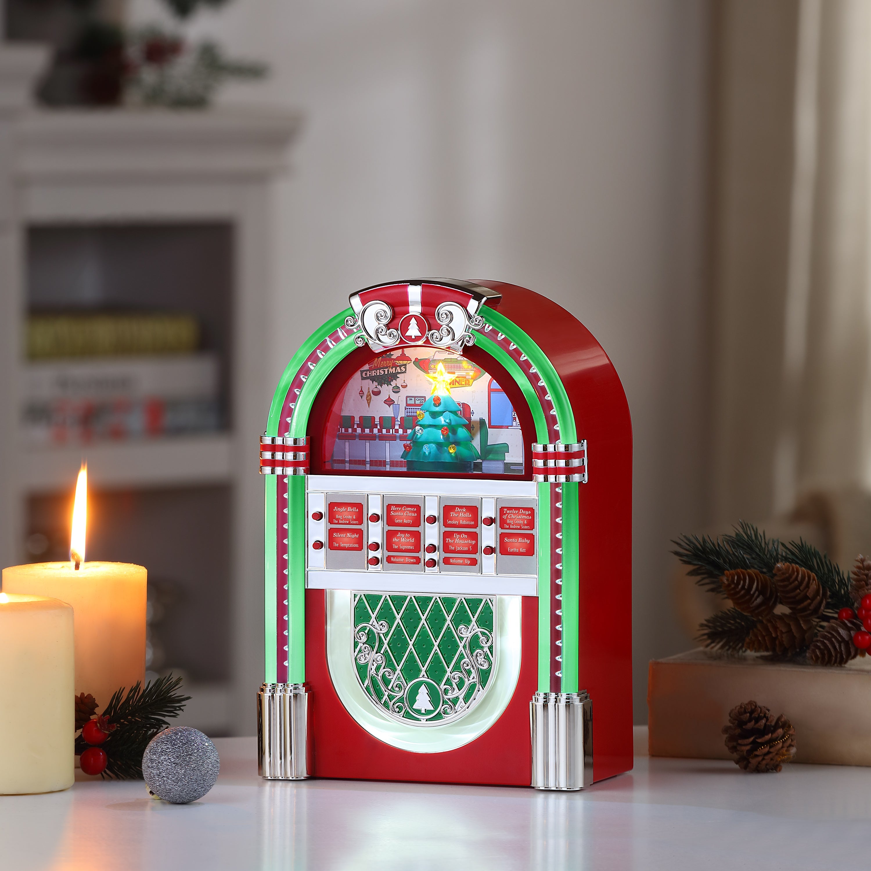 Mr. Christmas Rock-O-Rama Jukebox displayed on a tabletop with holiday decor, glowing as it plays classic Christmas tunes.